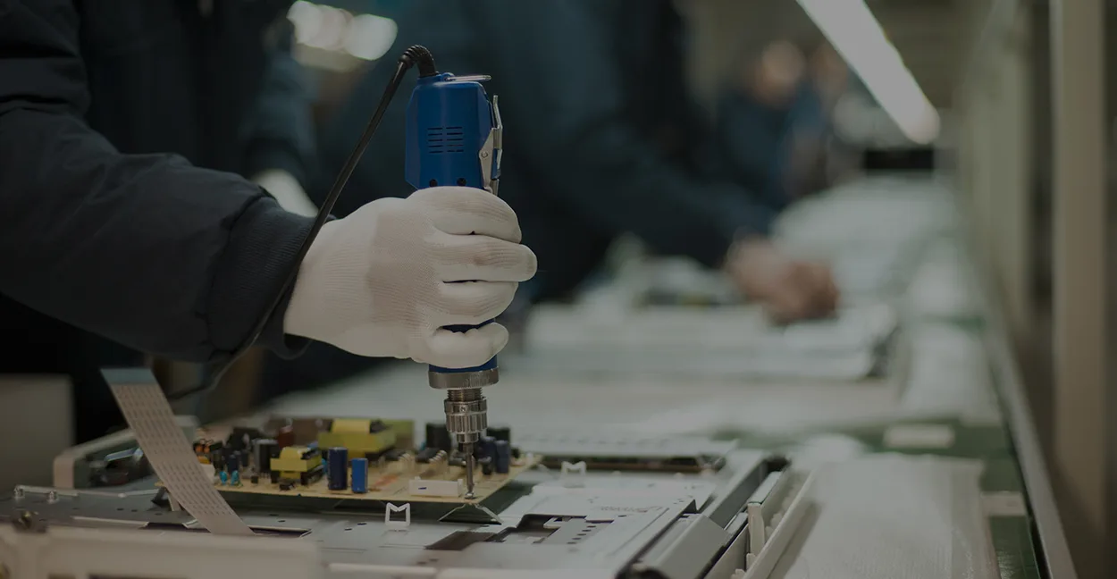 Close-up of hands working with industrial assembly equipment